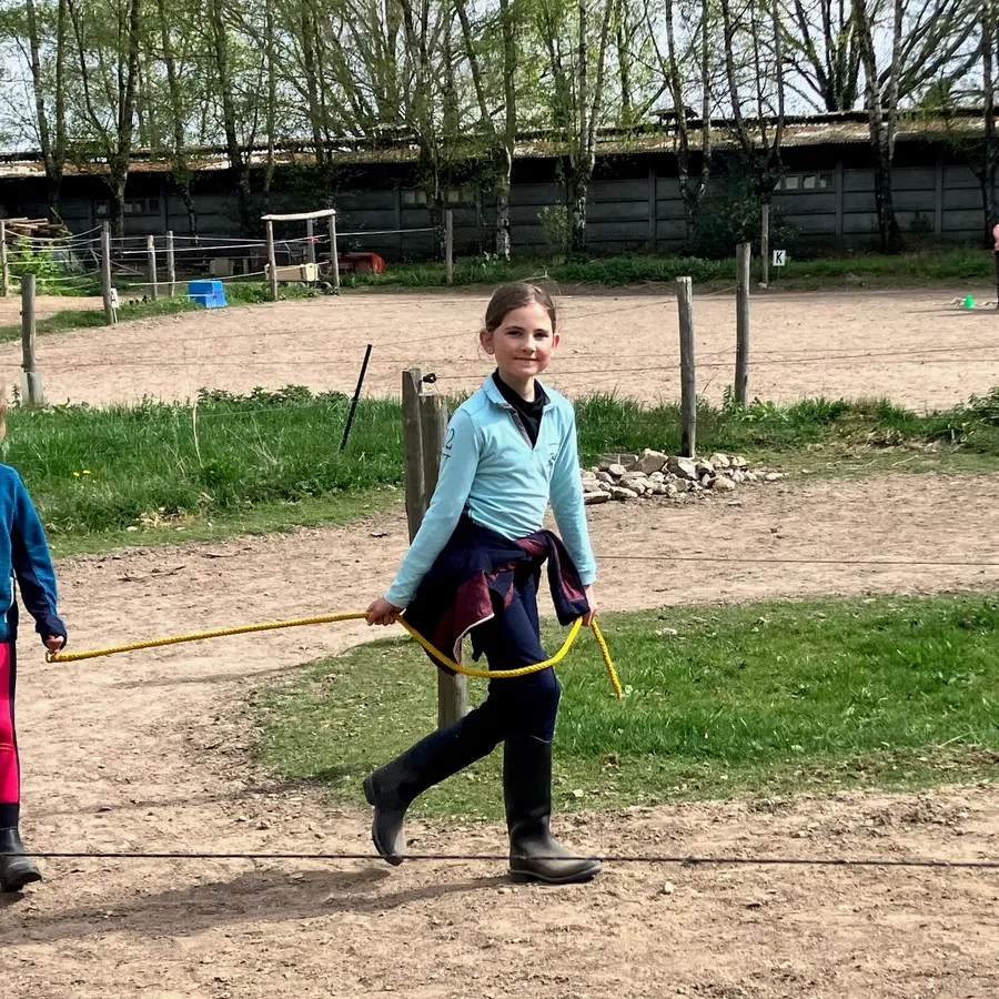 Jonge ruiter oefent vaardigheden naast de pony